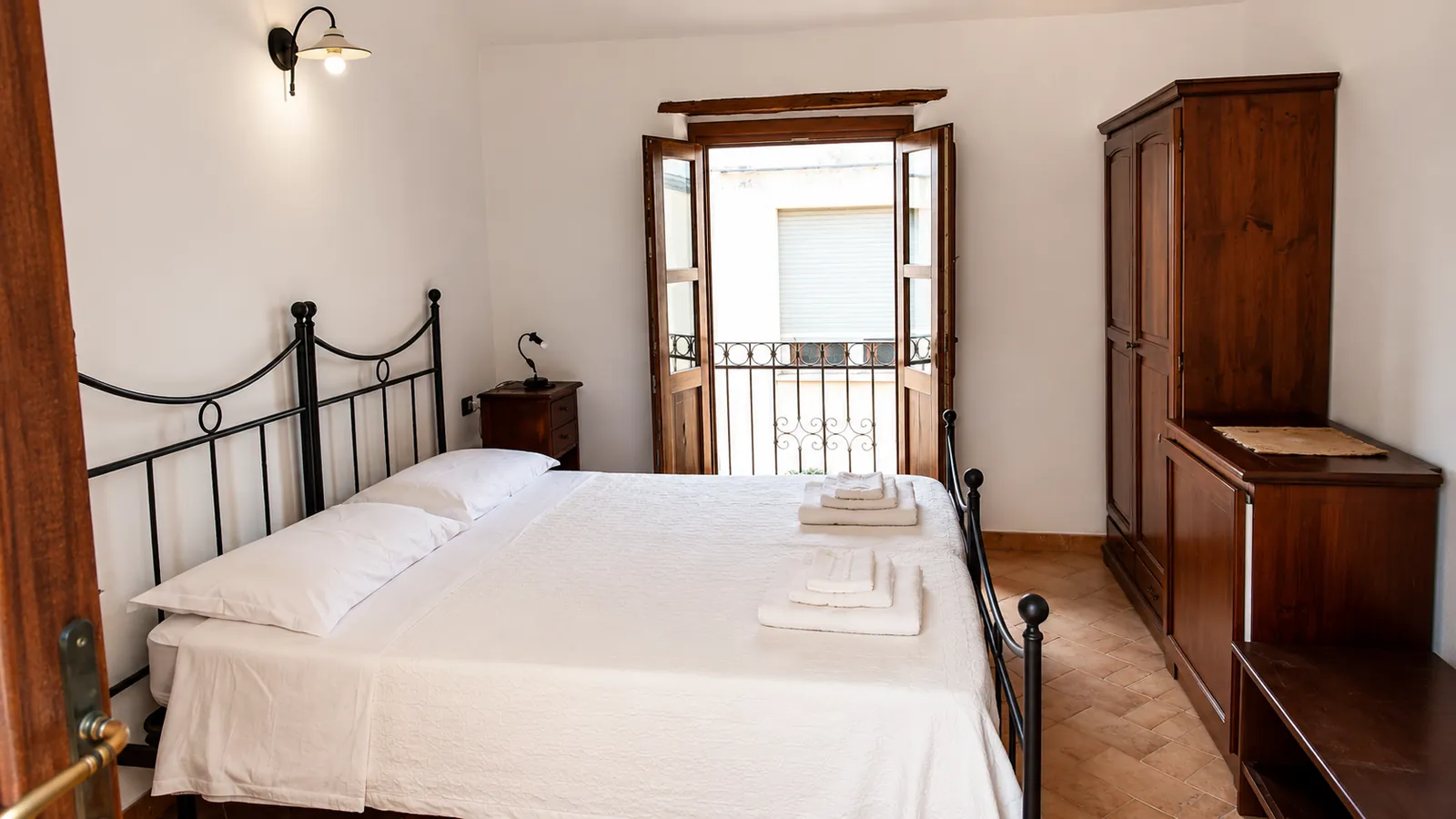 Camera matrimoniale con letto in ferro battuto e balcone, boutique hotel a Galtellì