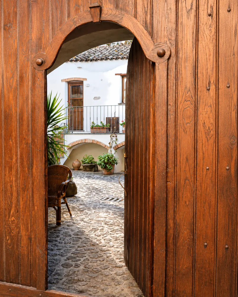 Portale in legno antico che si apre sulla corte dell'Antico Borgo